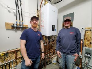 HVAC technician repairing a residential air conditioning unit in Baldwin, WI during summer